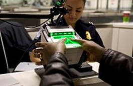 A person using the US-VISIT scanner at a customs check point. (Courtesy of Wikipedia/Released) 