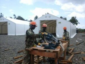 Supporting Operation United Assistance, Armed Forces of Libe-ria engineers work on the Tubmanburg Ebola treatment unit. Crews quickly put up a series of tents on freshly leveled and graveled ground. The U.S. Agency for International Develop-ment is the lead U.S. Government organization for Operation United Assistance. U.S. Africa Command is supporting the effort by providing command and control, logistics, training and engineering assets to contain the Ebola virus outbreak in West African nations. (U.S. Army Africa photo /Released) 