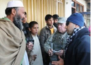Ed Campbell, Department of the Army employee with the Human Terrain Team from Task Force Cyclone, and his in-terpreter stop and talk with a local shop owner in the city of Bagram in Parwan province, Afghanistan. (U.S. Army photo by Spc. Charles Thompson/Released)