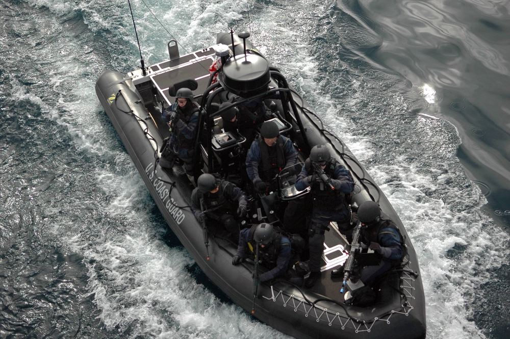 Several personnel in a boat conducting a training exercise.