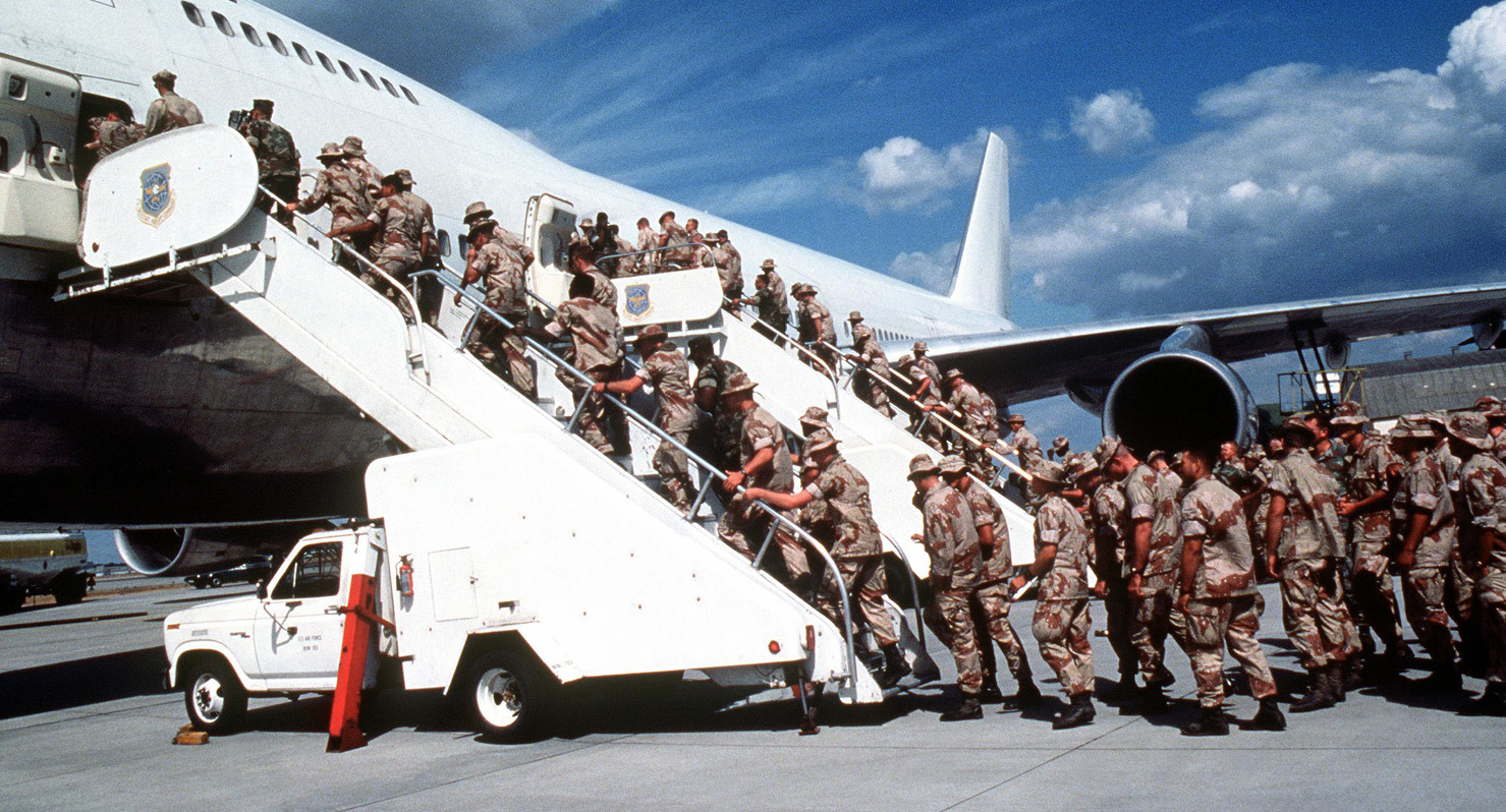 Figure 3. U.S. Marines Board a Commercial Aircraft Chartered by U.S. Military Airlift Command at an Undisclosed Location During Operation Desert Shield, September 1990.