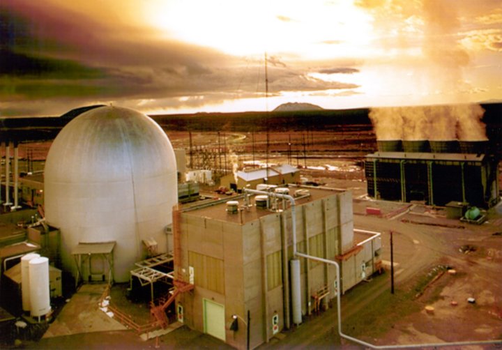 A picture of a nuclear testing facility, with a domed structure to the left and a building in the foreground.