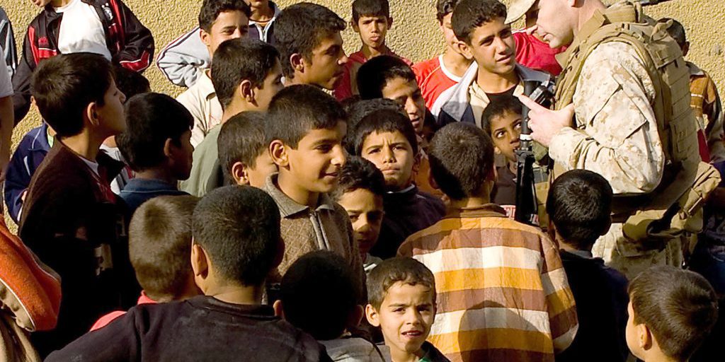 1st Lt. David Johnson talks with Iraqi children during a visit to the Basra's Al Hayyaniah District on December 25, 2008. Human terrain mapping helps Marines on the ground understand how to positively interact with the local Iraqi populace.