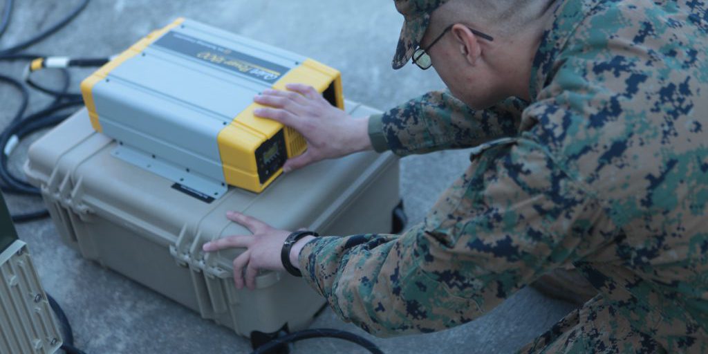 Lance Cpl. Joshua Chaffee, a field radio operator with Headquarters Company, 8th Marine Regiment, 2nd Marine Division, ensures a converter is correctly functioning which will allows the power held in several high energy lithium batteries can be turned into useable energy. (DVIDS/USMC)