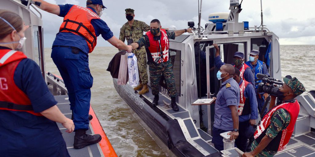 U.S. Coast Guard Lt. Cmdr. Jason McCarthey, Operations Officer of the USCGC Stone (WMSL 758), exchanges gifts with members of the Guyana Coast Guard off the coast of Guyana on January 9, 2021. After enacting a bilateral agreement on September 18, 2020, the U.S. Coast Guard and Guyana Coast Guard completed their first cooperative training exercise to practice combating illicit marine traffic (U.S. Coast Guard photo by Petty Officer 3rd Class John Hightower).