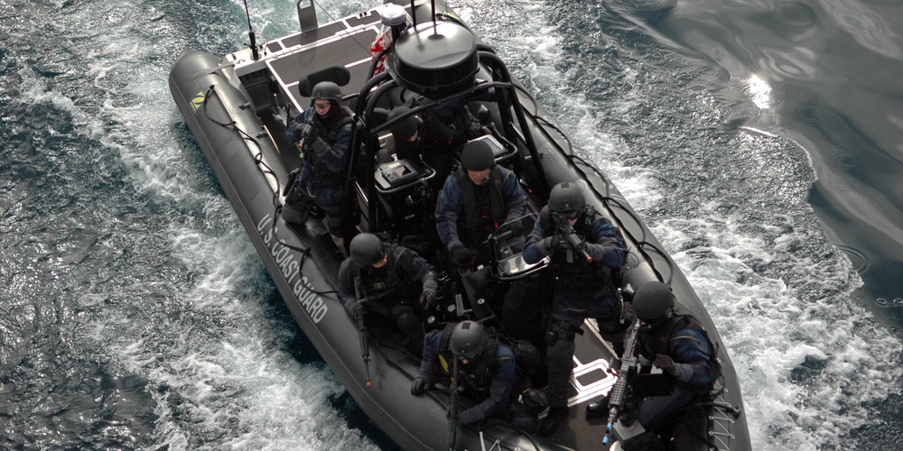 Several personnel in a boat conducting a training exercise.