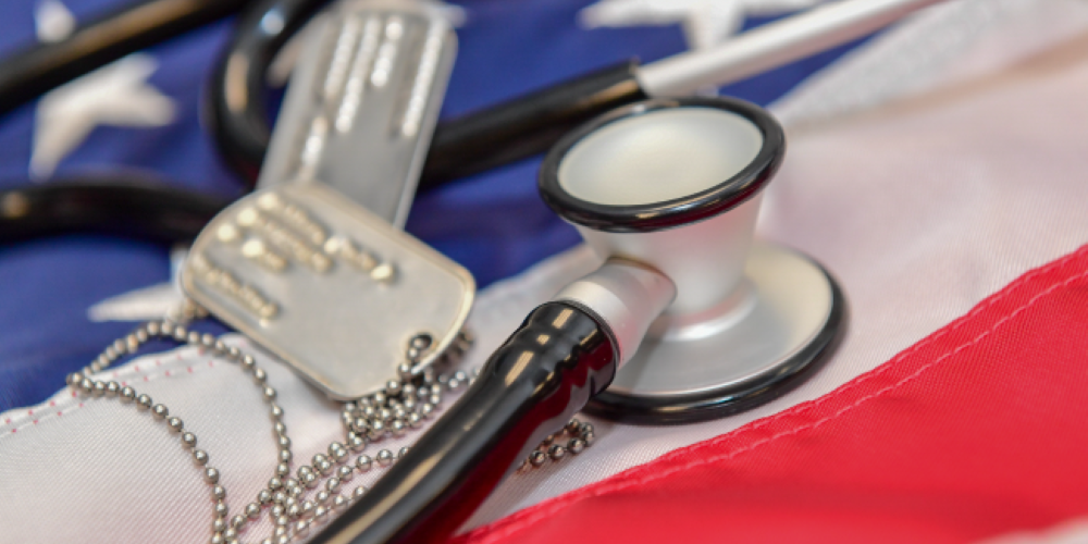 Stethoscope and dog tags laying on a Flag of the United States.