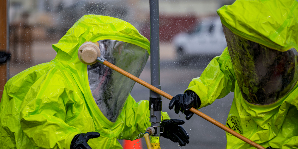 Physical and chemical decontamination of personnel in protective suits.