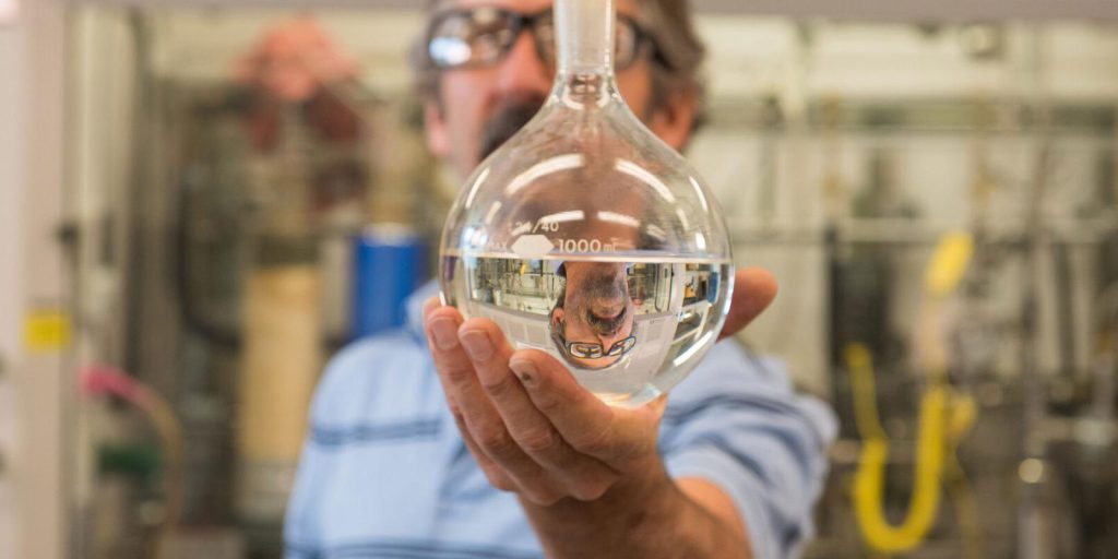 PNNL’s Rich Hallen holds a sample of jet fuel upgraded from ethanol made from industrial waste gases
(photo by Andrea Starr | PNNL).
